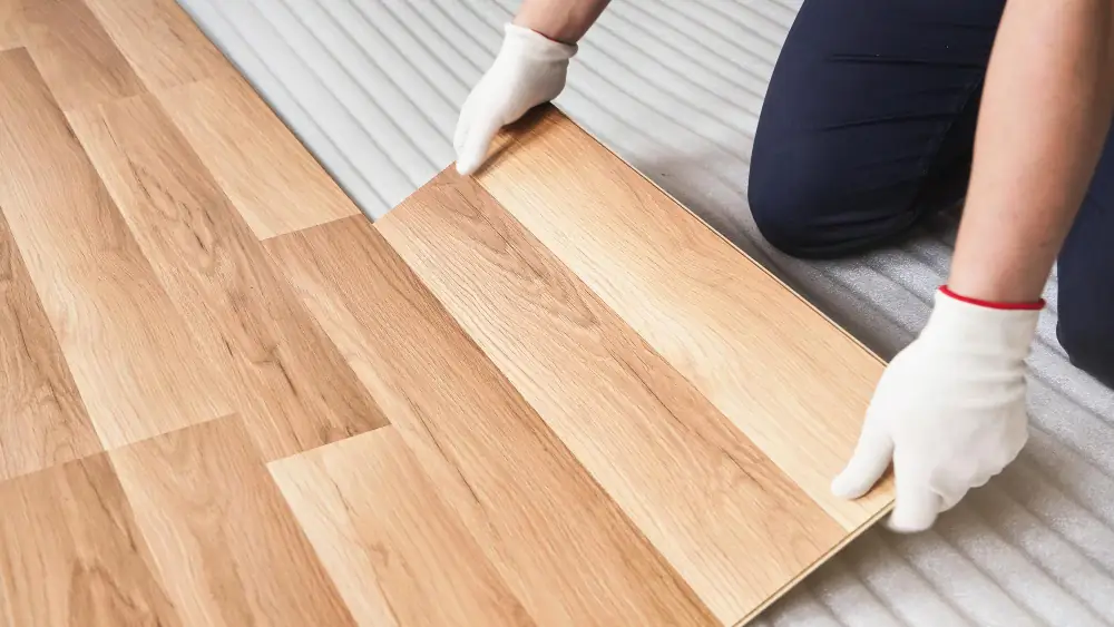 Flooring Contractor aligns new laminate over an insolation