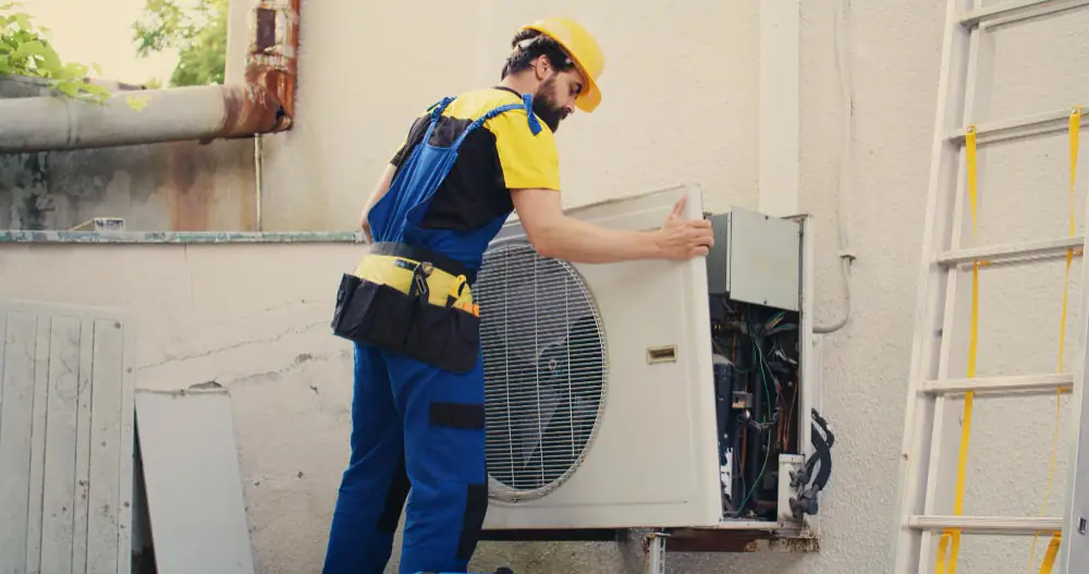 HVAC employee removes a outdoor unit cover of an AC